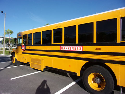 A Florida school bus with a HAPPINESS sign